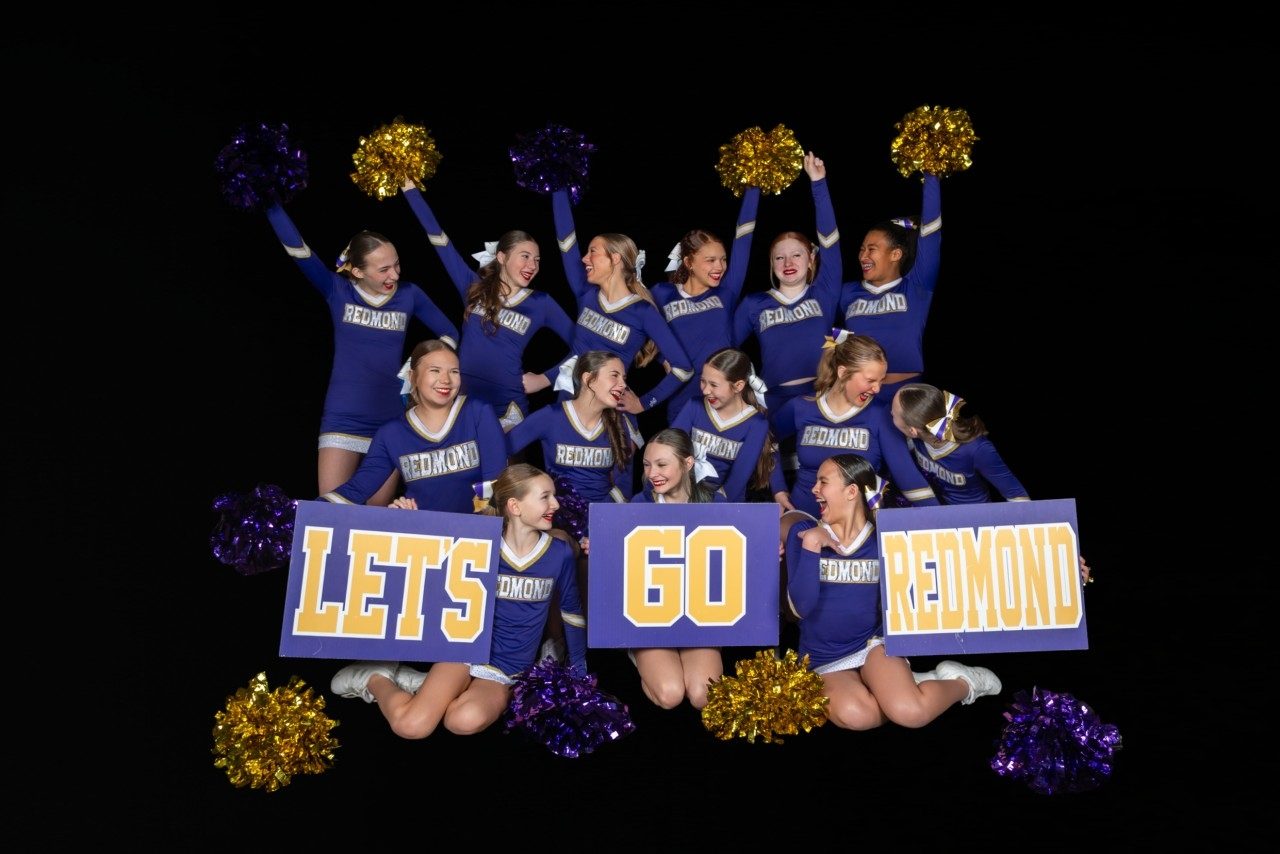 Junior team studio photo holding Let's Go Redmond signs